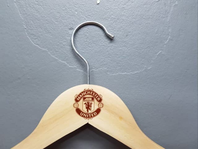 สกรีนไม้แขวนเสื้อ โลโก้เเมนยู | รับสกรีนโลโก้ ราคาถูก ไม่มีขั้นต่ำ